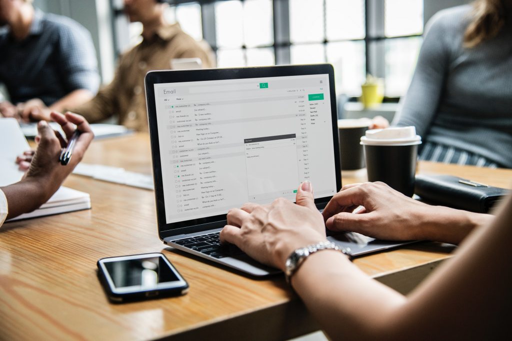 Person checking email on laptop during meeting