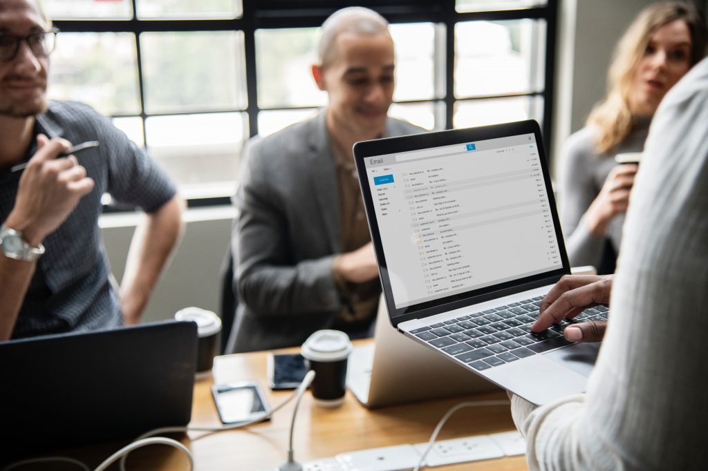 Team meeting with laptop showing email inbox